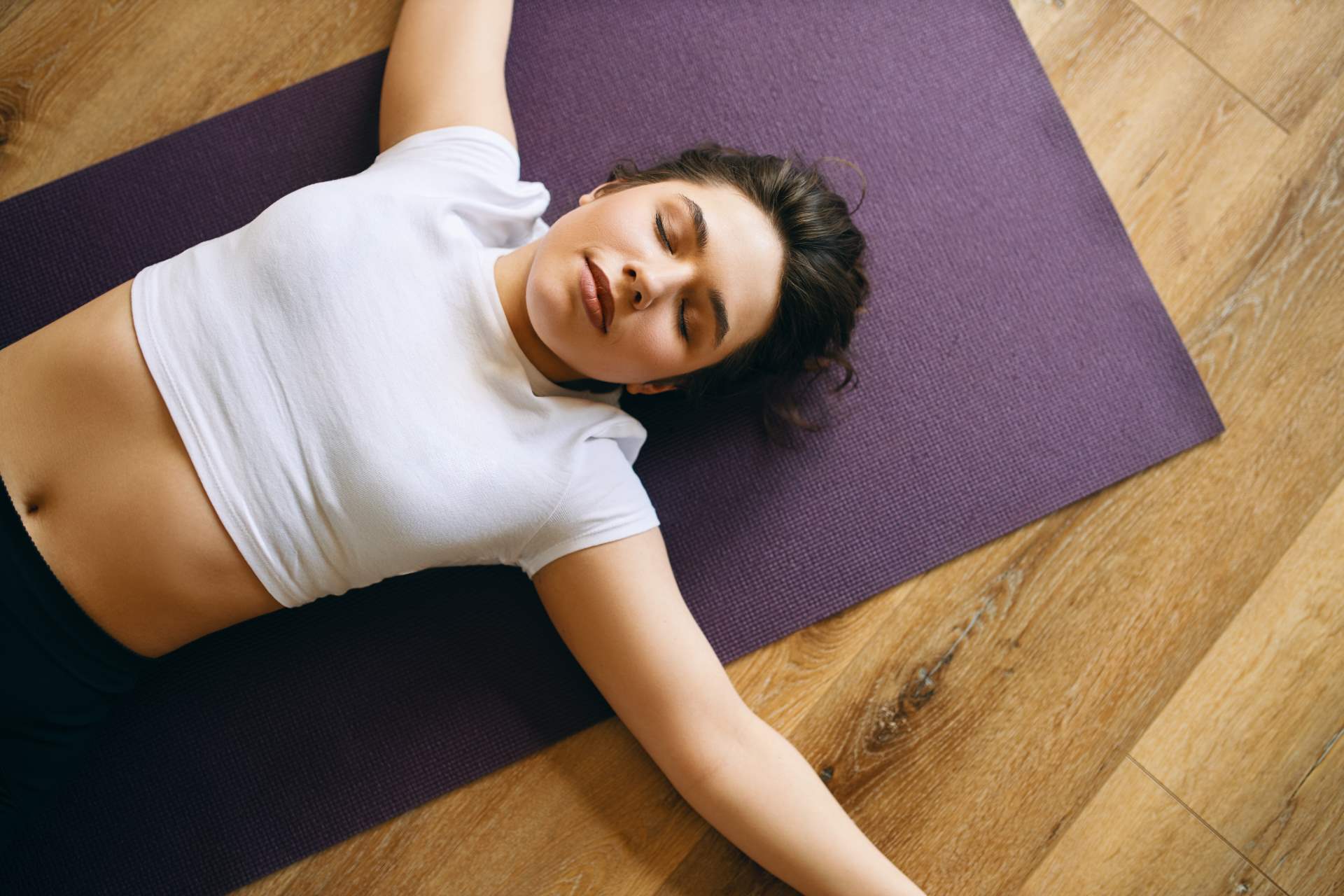 Draufsicht-schöne-junge-Frau-weiße-Pflanze-Dachliege-Shavasana-Korpus-Haltung-Yoga-Nidra-Kurs-Ruhen-nach-der-Übung-meditierend-atmend-tief-entspannend-Ruhe-Konzept